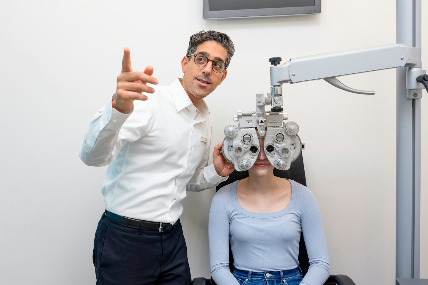 An optician guides a patient during an eye examination.