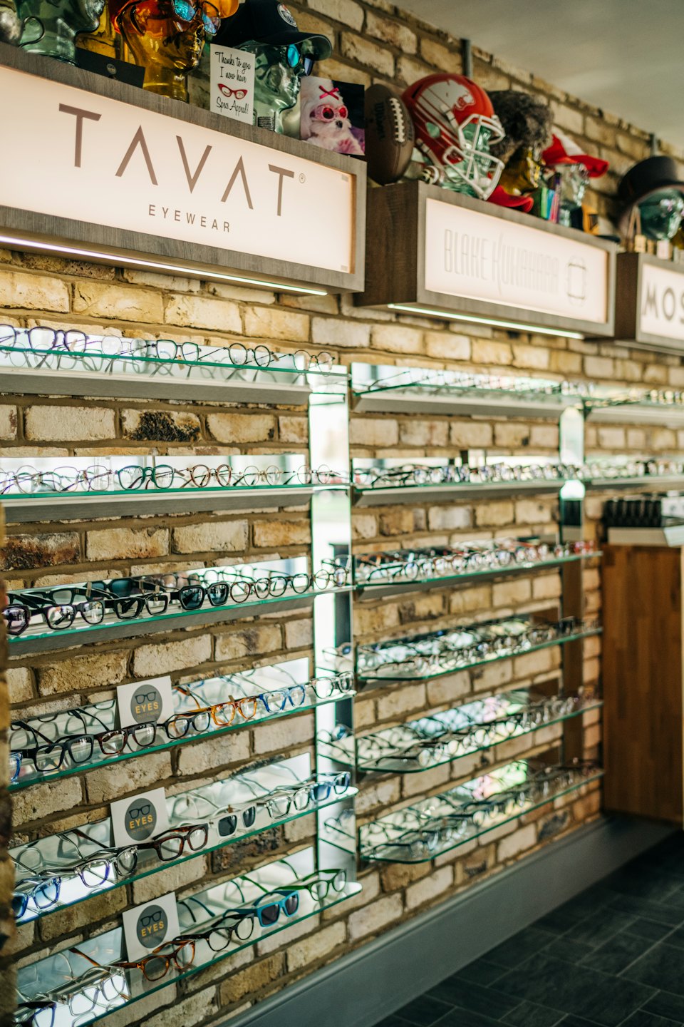 Eyeglasses and sunglasses displayed on shelves inside an optical store.